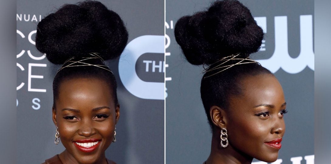 Lupita Nyongo at red carpet with hair pulled into a tight bun that is fluffed to look like clouds