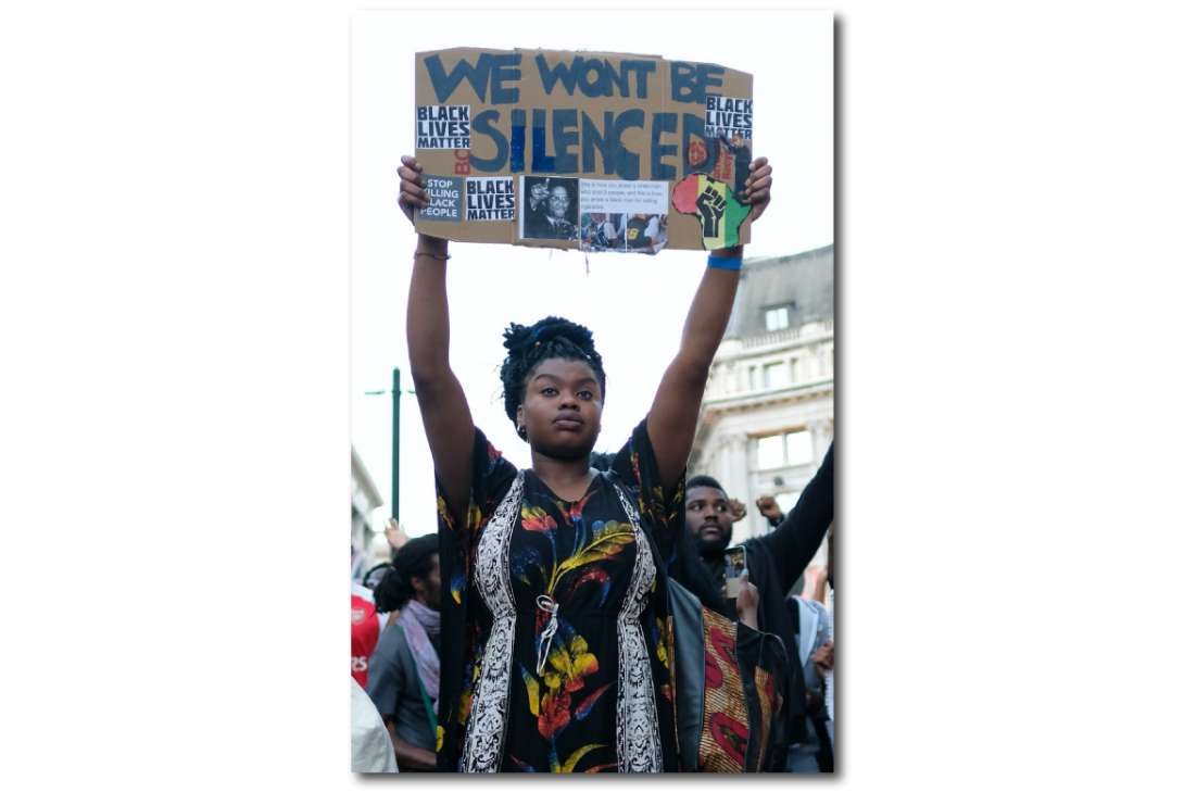 Image of black female protestors holding signs like black lives matter and we wont be silenced